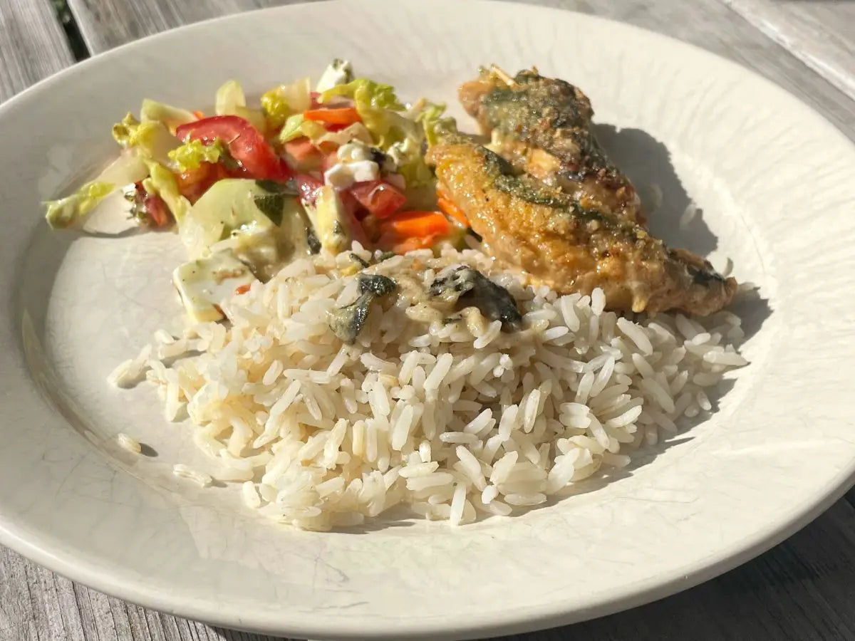 Hähnchen-Saltimbocca mit Salbei, Reis und Tomatensalat auf einem hellen Teller, von oben