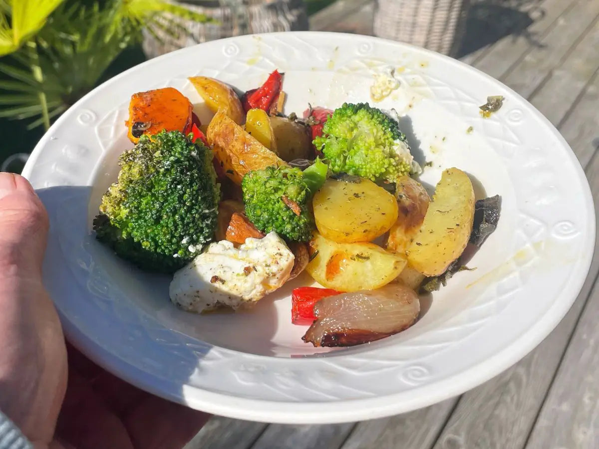 Ofenkartoffeln mit Rosmarin, Brokkoli, Kürbis, Paprika, Feta und roter Zwiebel auf einem weißen Teller