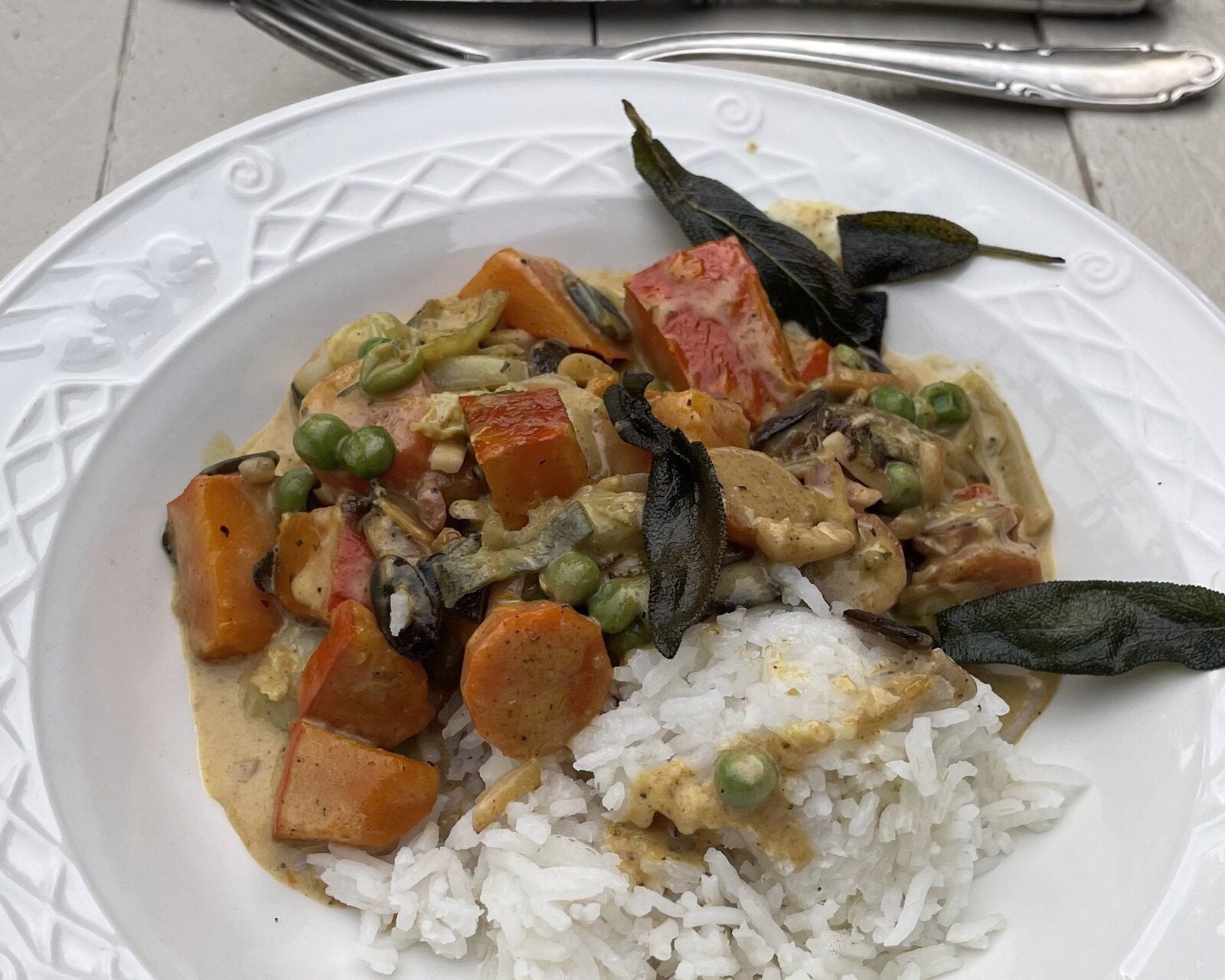 Kürbis-Curry mit Rosenkohl, Erbsen, Reis und knusprigem Salbei, dahinter die Dose STRANDBY