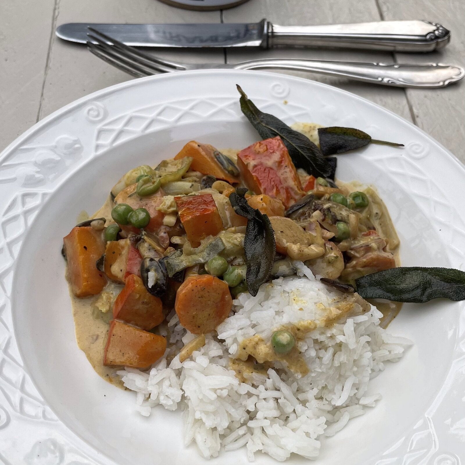 Kürbis-Curry mit Rosenkohl, Erbsen, Reis und knusprigem Salbei, dahinter die Dose STRANDBY
