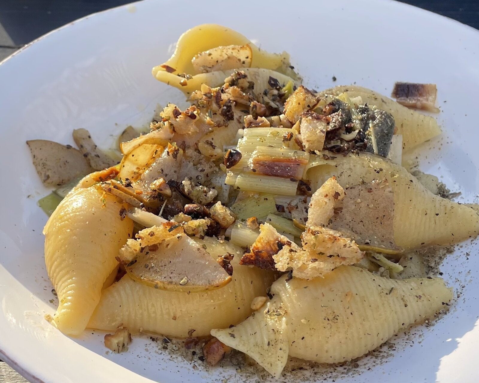 Pasta mit Lauch, gebratener Birne und Walnuss-Bröseln im tiefen Teller, dahinter die Dose LISTA