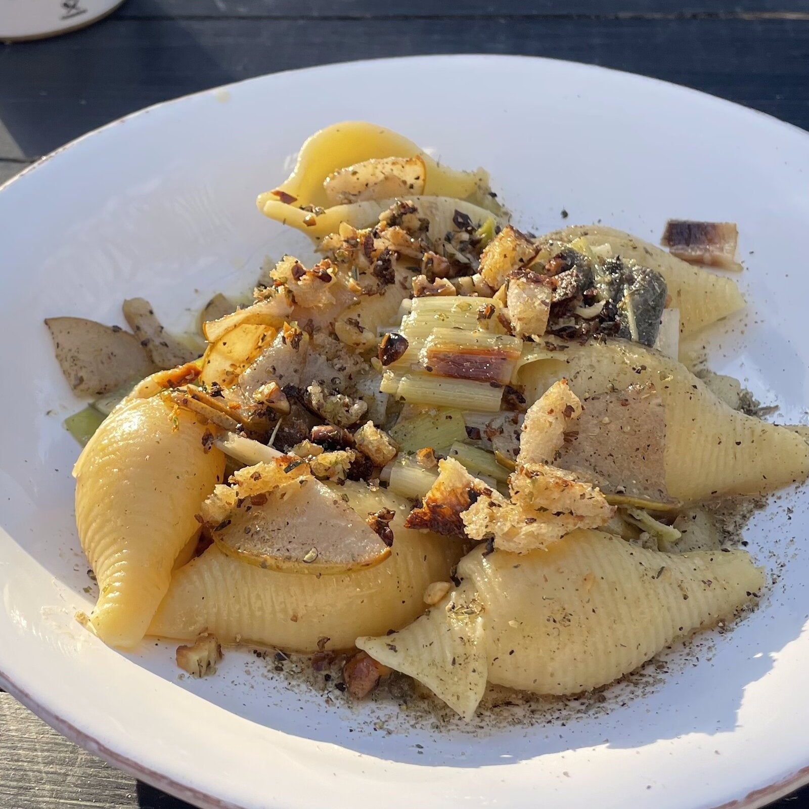 Pasta mit Lauch, gebratener Birne und Walnuss-Bröseln im tiefen Teller, dahinter die Dose LISTA